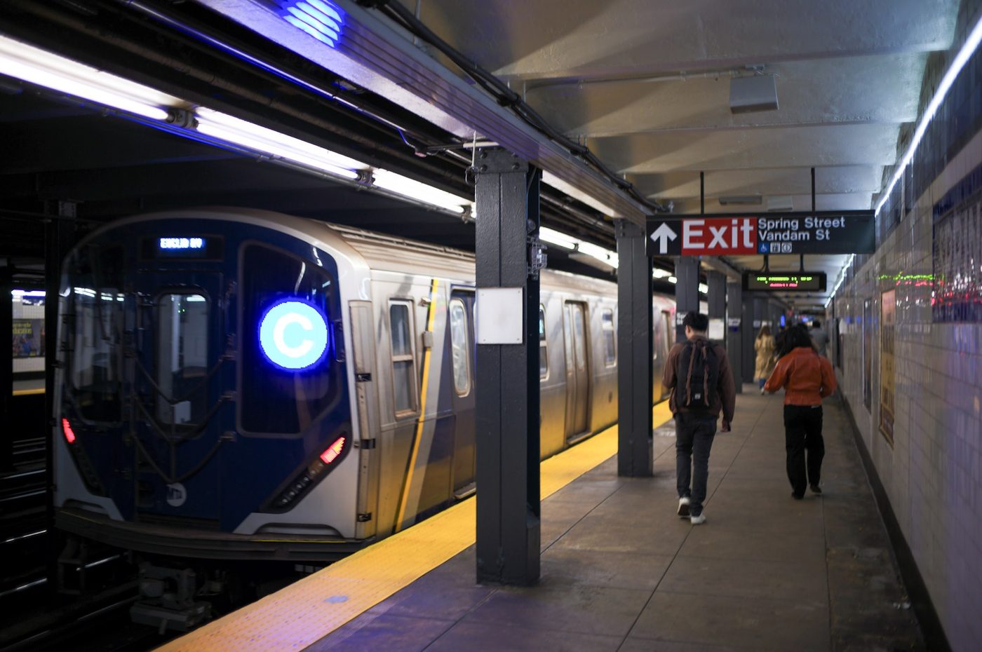 Une rame C entre en station Spring Street, des voyageurs marchent sur le quai